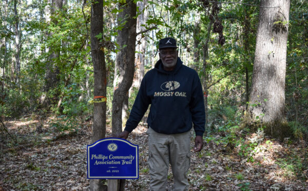 illips community president Richard Habersham with the community's new walking trail sign