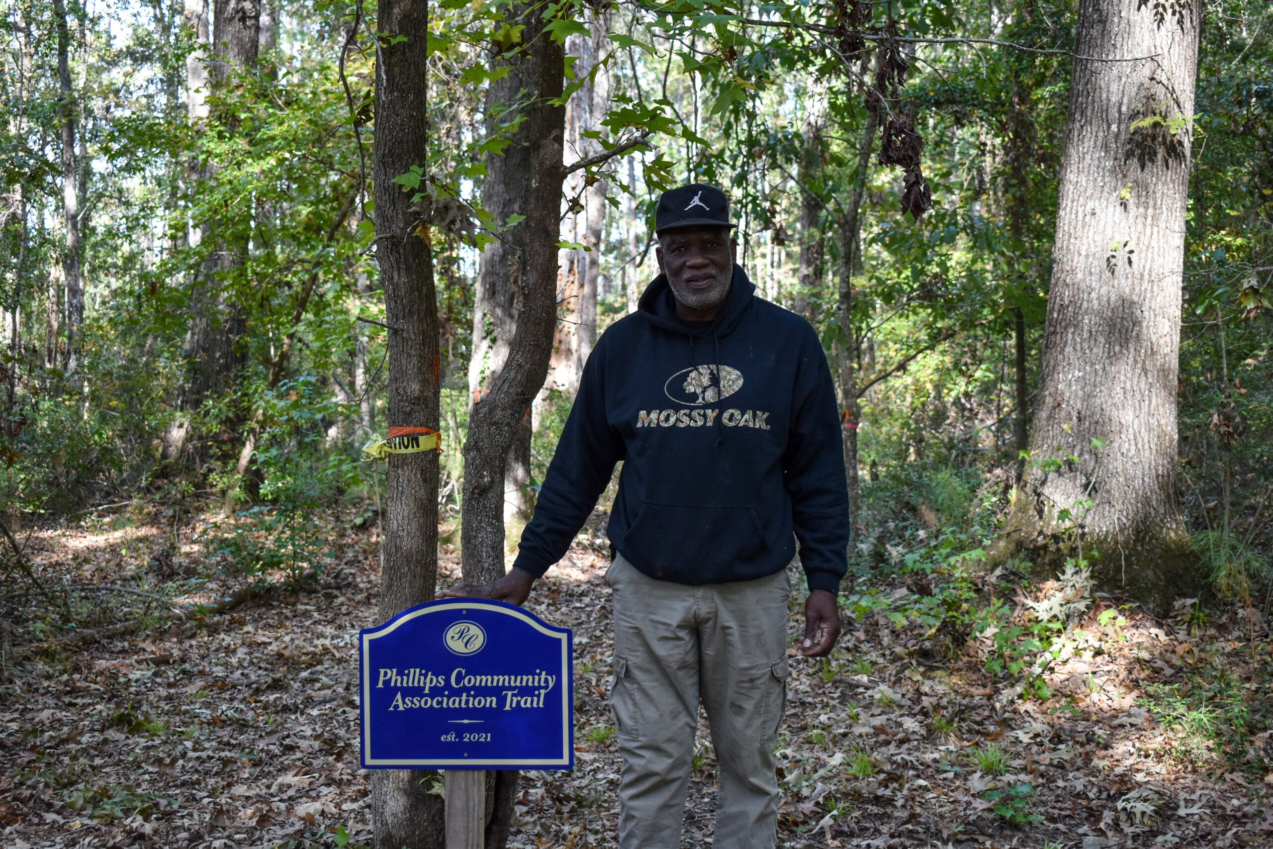 Phillips community president Richard Habersham with the community's new walking trail sign