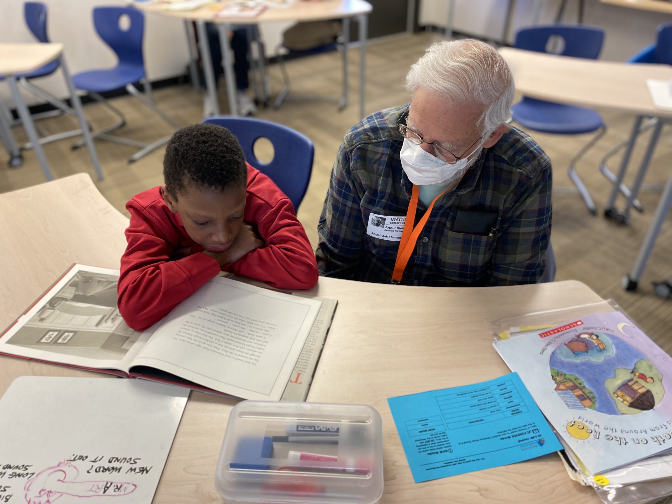 Tutor from reading partners sits with students