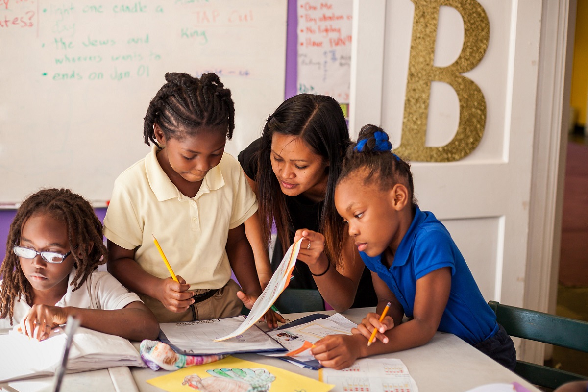 Teachers works with students on their homework